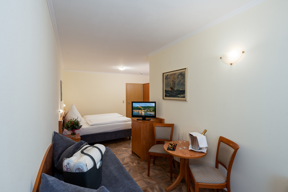 Doppelzimmer Standard - Triton - moselstern.de - Zimmer 17 - Hotel Brixiade & Triton - Bett - TV - Sofa - Zimmeransicht